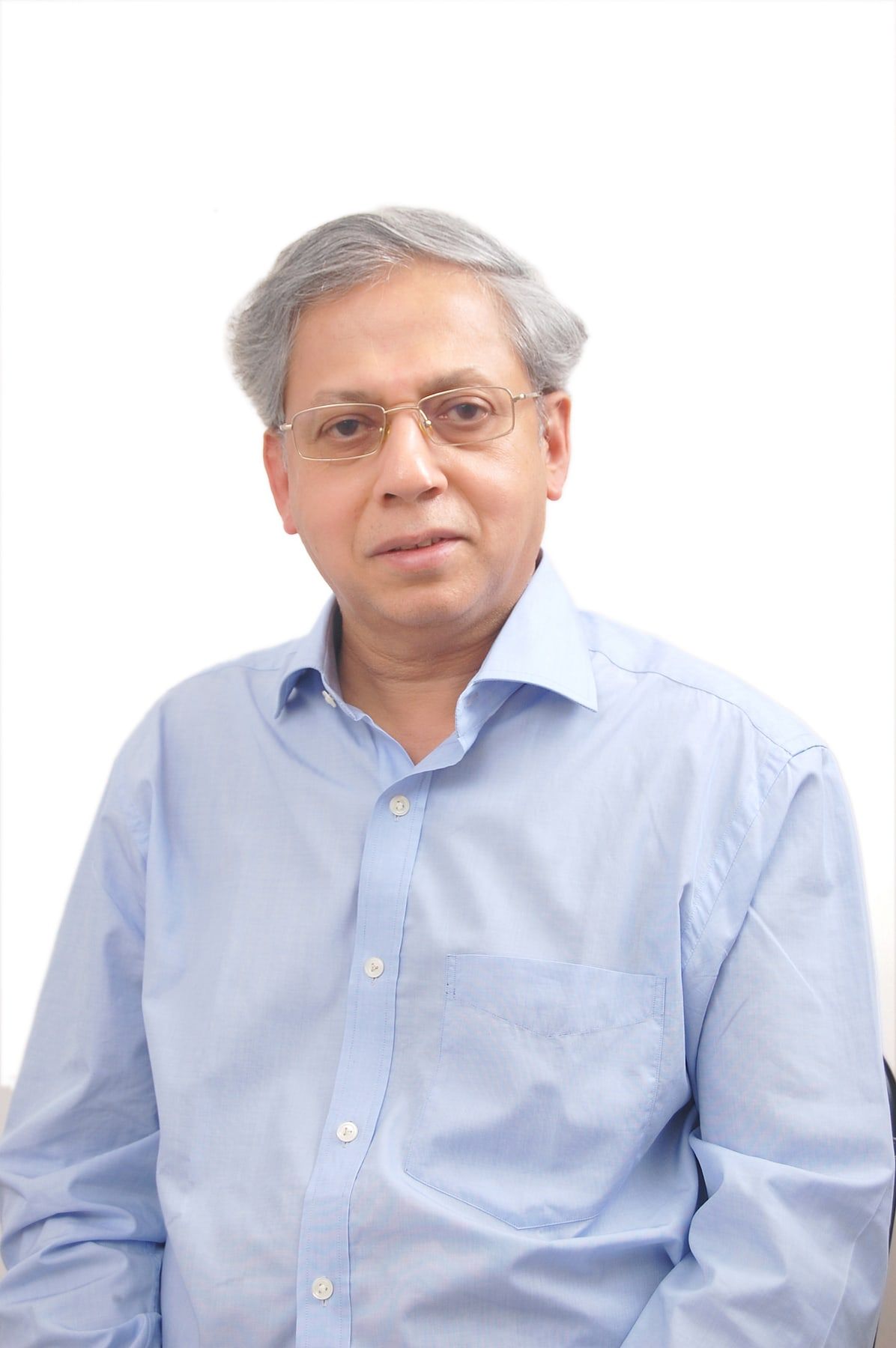 Neelakanth Phadke in a pale blue shirt and spectacles, against a plain light background.